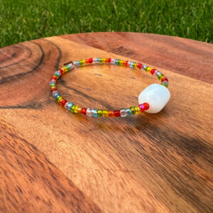 The Rainbow Bracelet with rainbow beads surround a white accent bead.