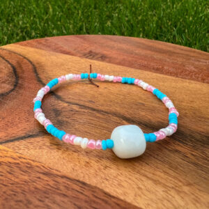 The Transgender Rights Bracelet with pink, blue and white beads surround a white accent bead.