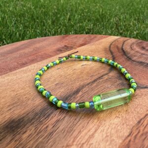 The Earth Bracelet with lime green, dark green, and blue beads surround a green accent bead.