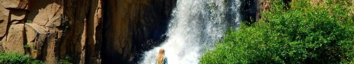 Jillian standing at the base of a waterfall.